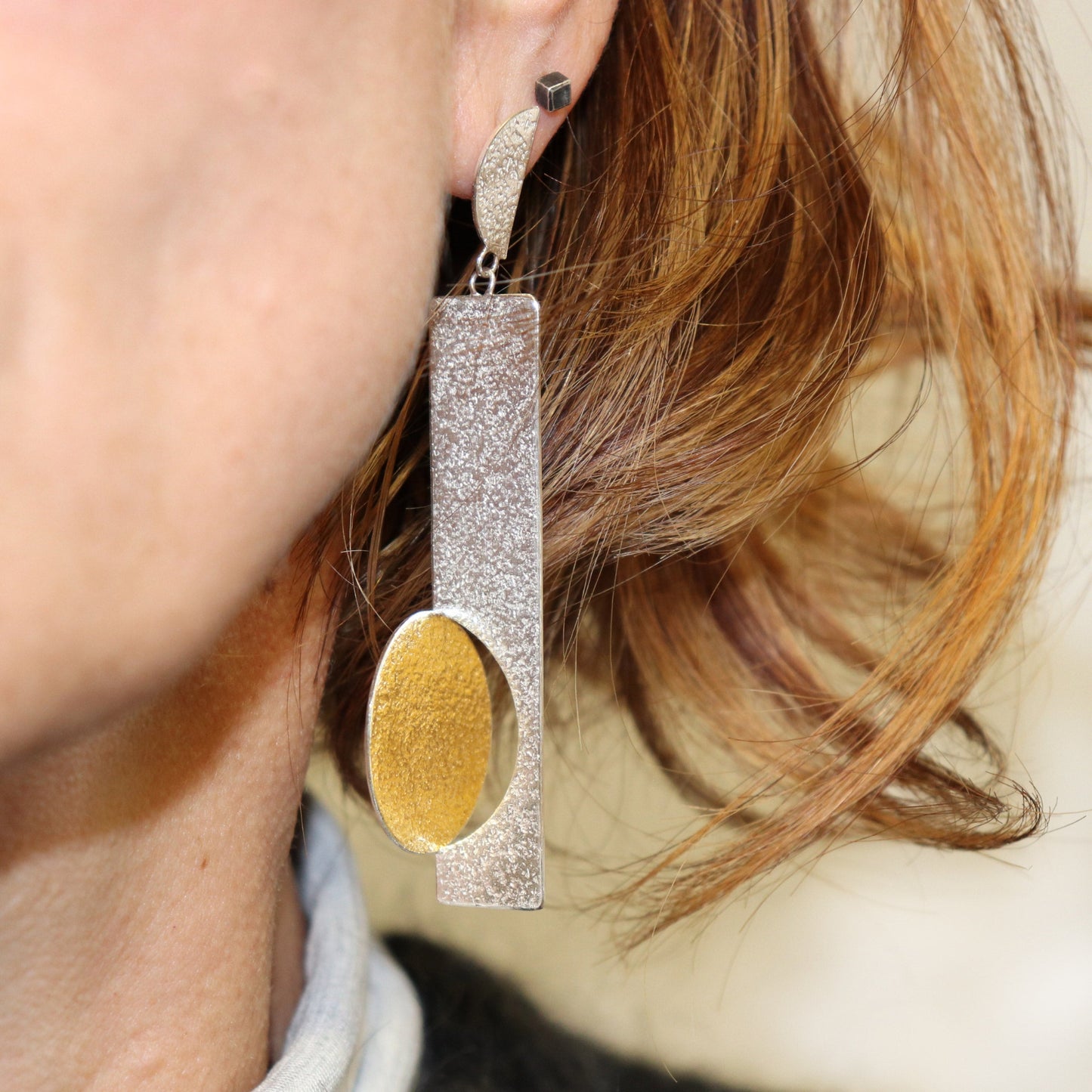 Inverted mismatched gold & silver bauhaus earrings modelled