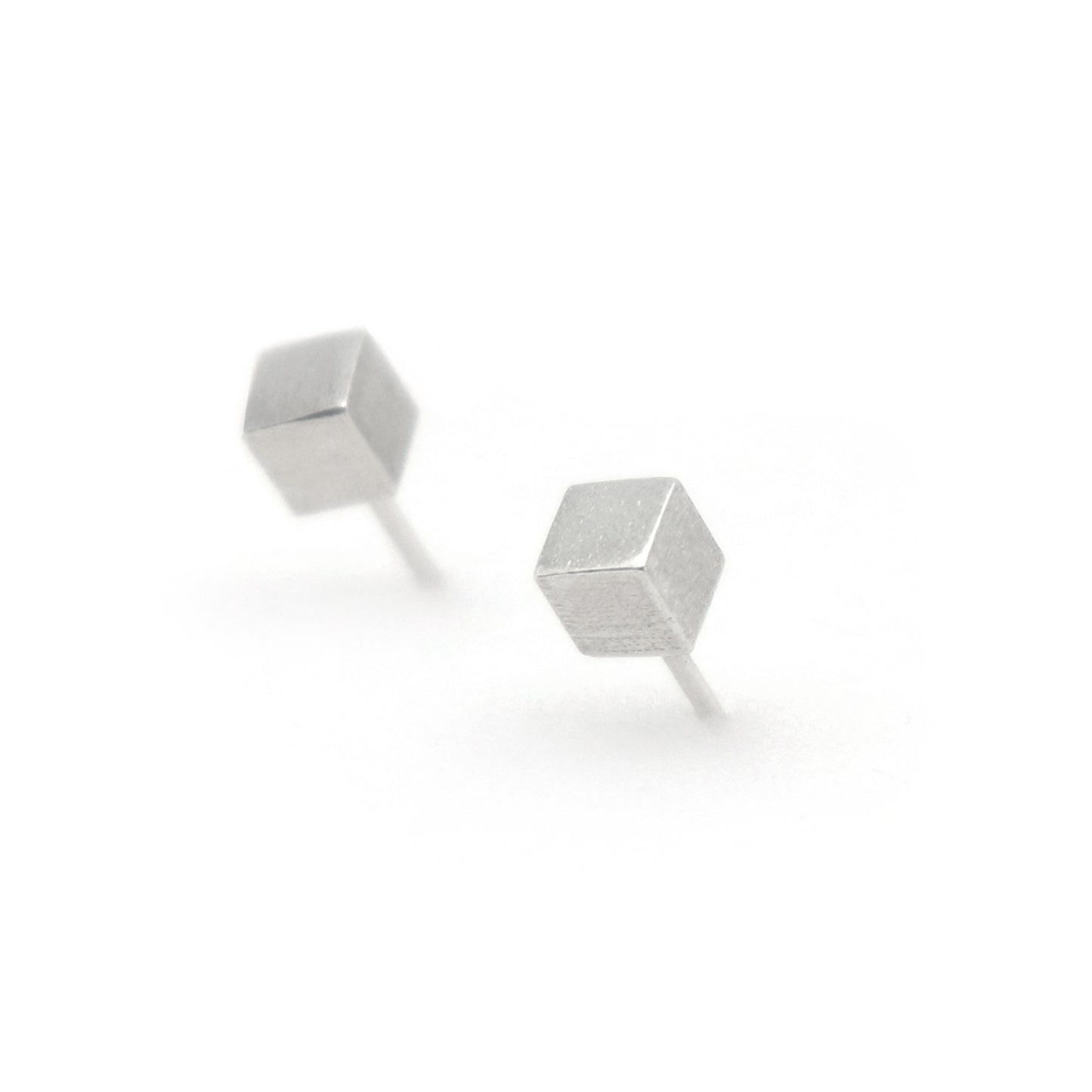 Pair of silver geometric cube stud earrings on a white background