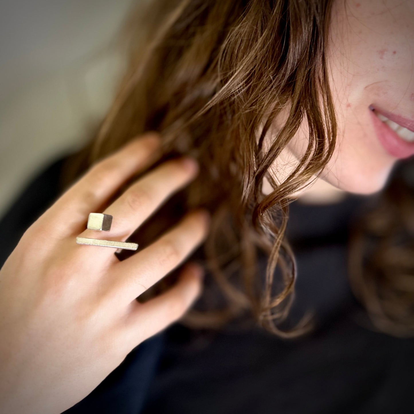 Close-up of a person wearing a silver ring with a blurred background