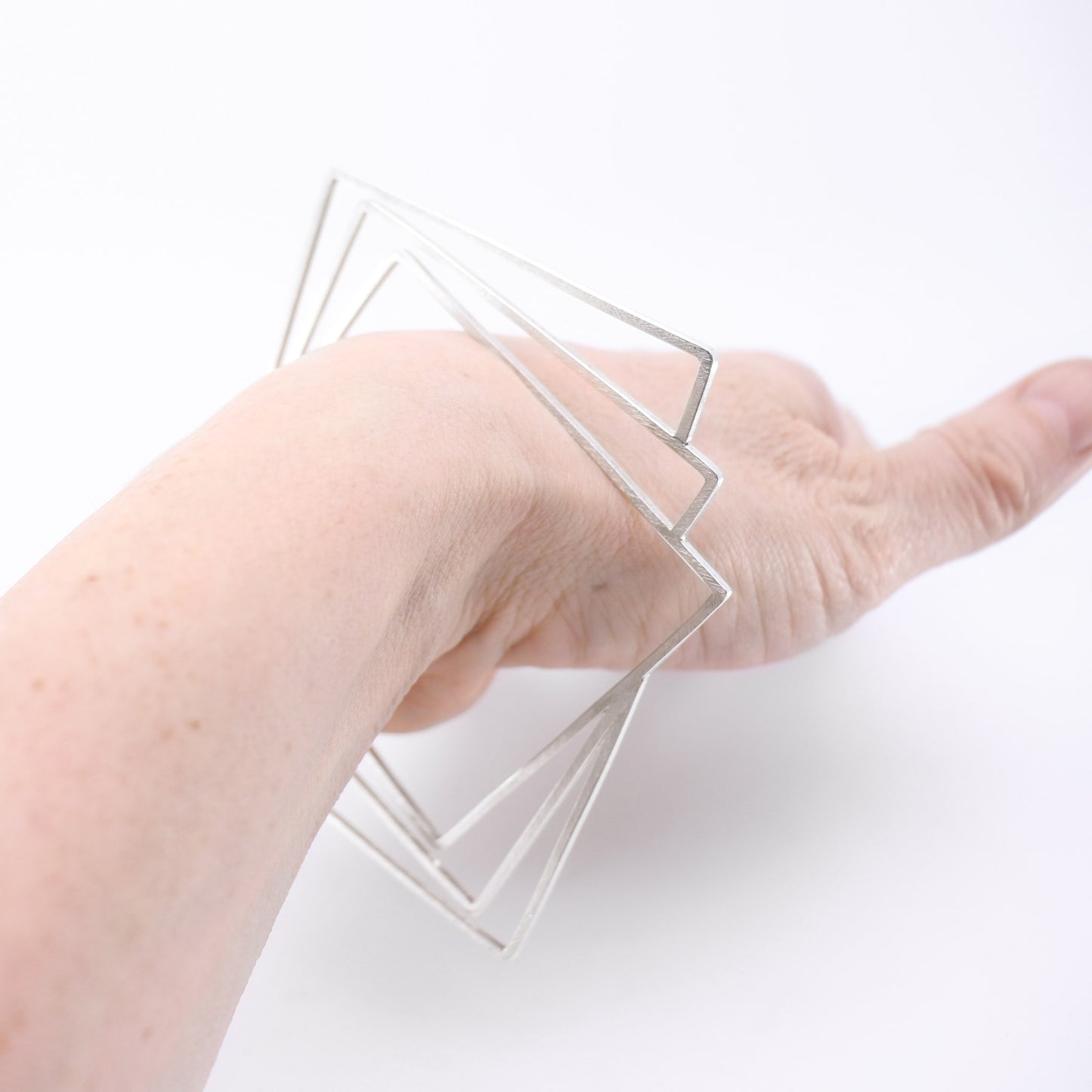 geometric silver bangle modelled on wrist