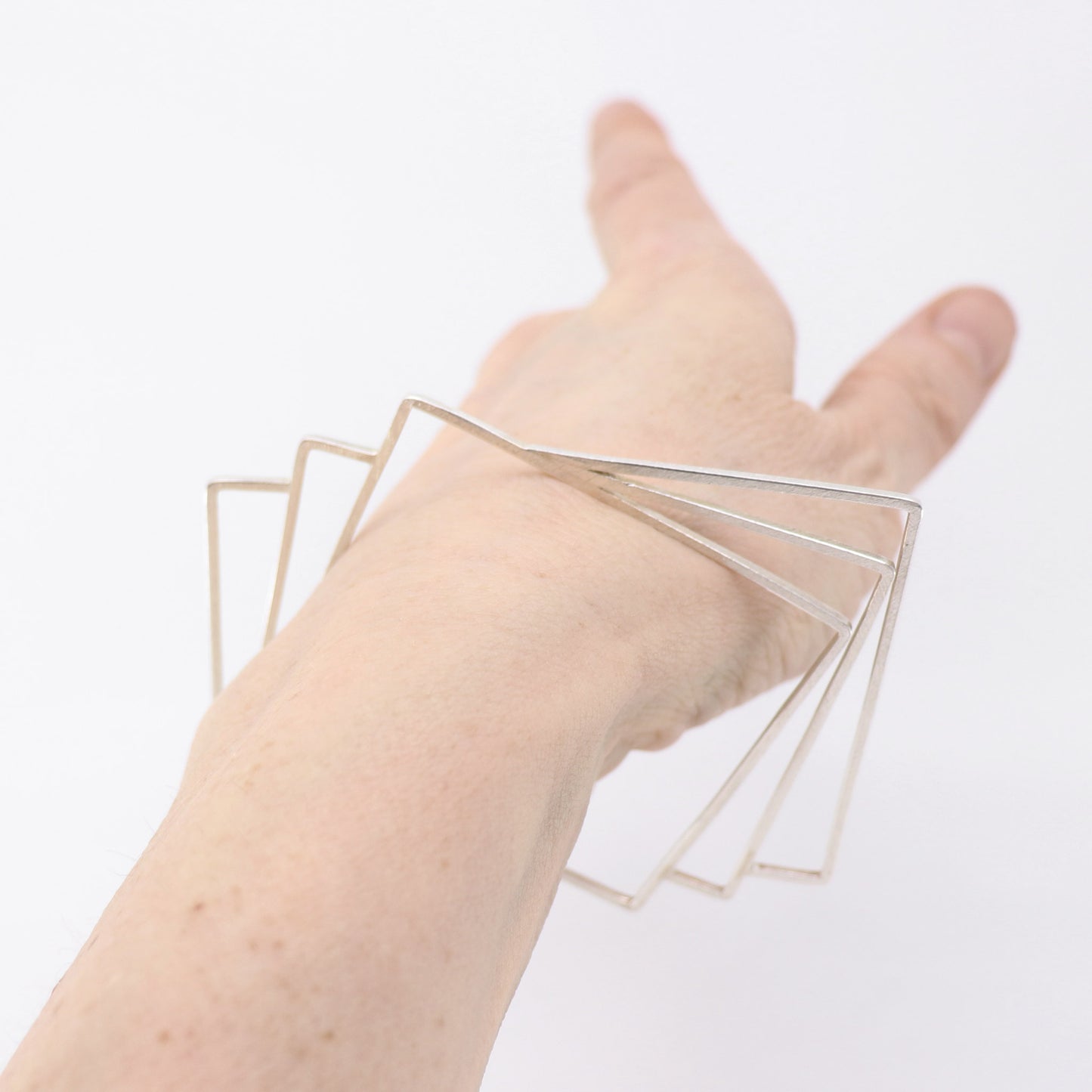 geometric silver handmade bangle modelled on wrist