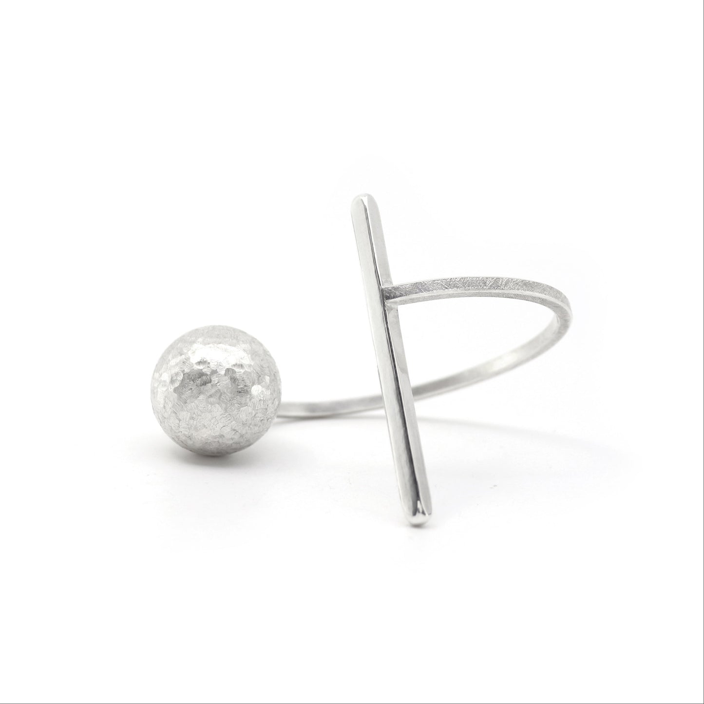 A minimalist sterling silver bangle cuff featuring a textured spherical bead and a flat, angled bar, displayed on a clean white background.