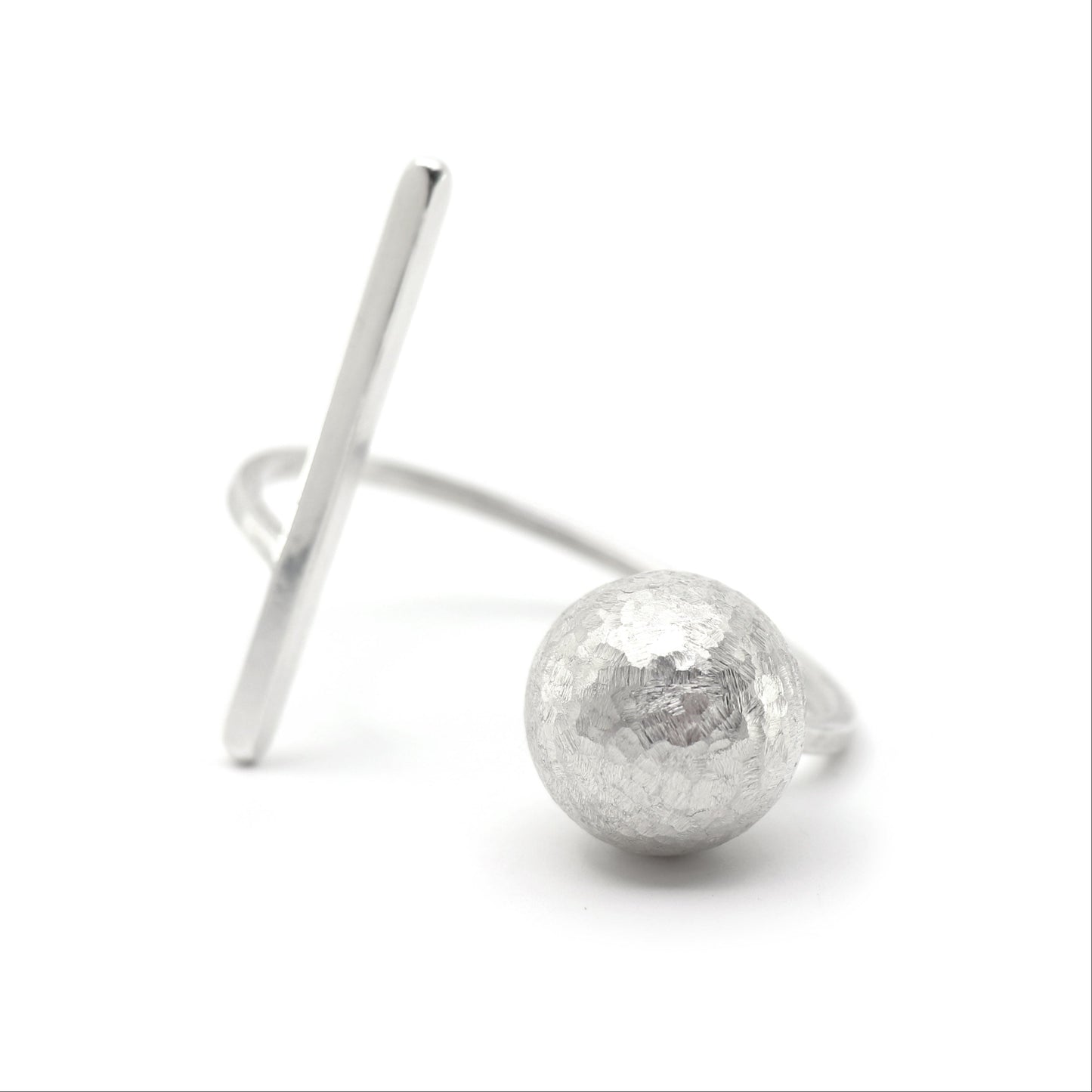 A silver cuff bracelet featuring a hammered-texture spherical bead and a flat, angled bar, photographed on a clean white background.