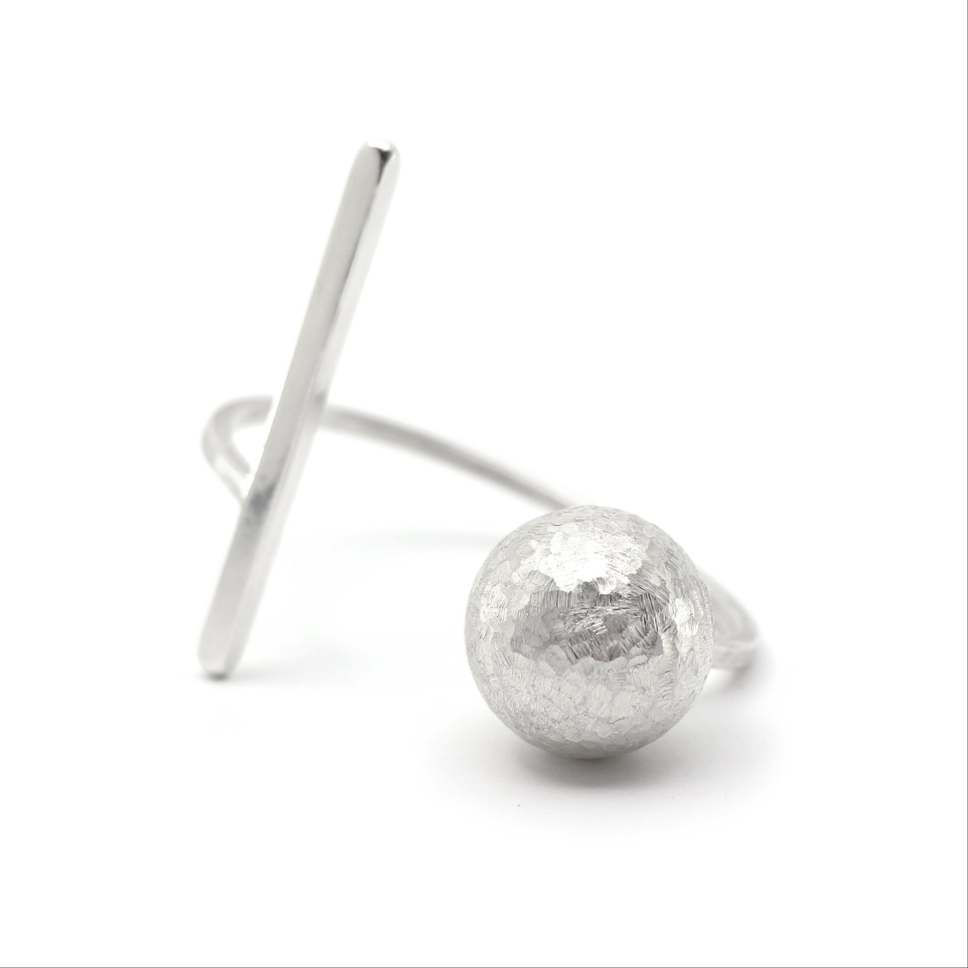 A silver cuff bracelet featuring a hammered-texture spherical bead and a flat, angled bar, photographed on a clean white background.