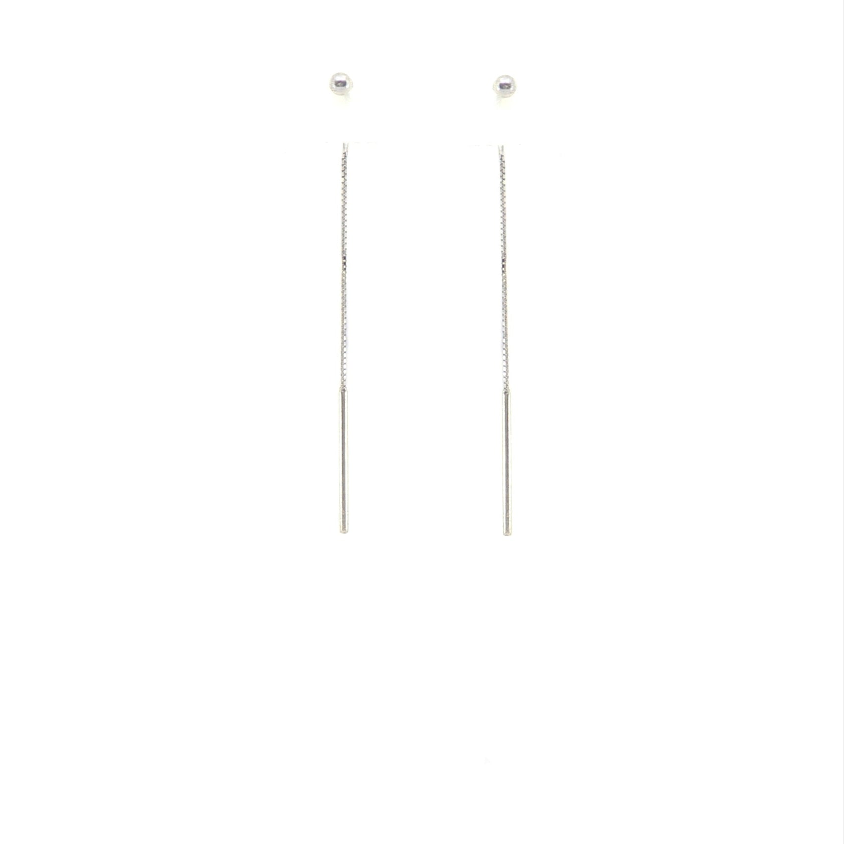 Pair of long thin ball threader earrings in sterling silver on a white background