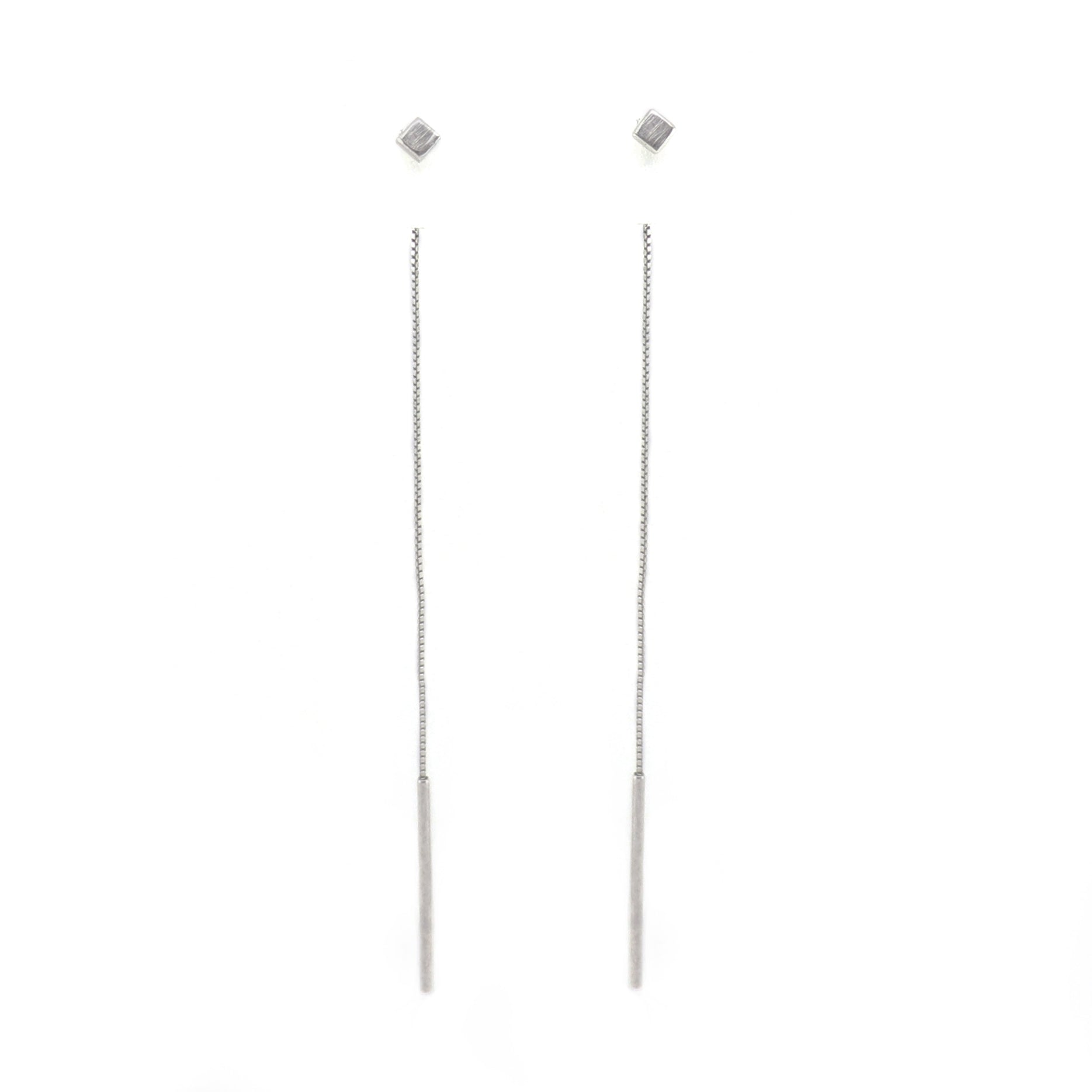 Pair of cube silver long thread earrings on a white background