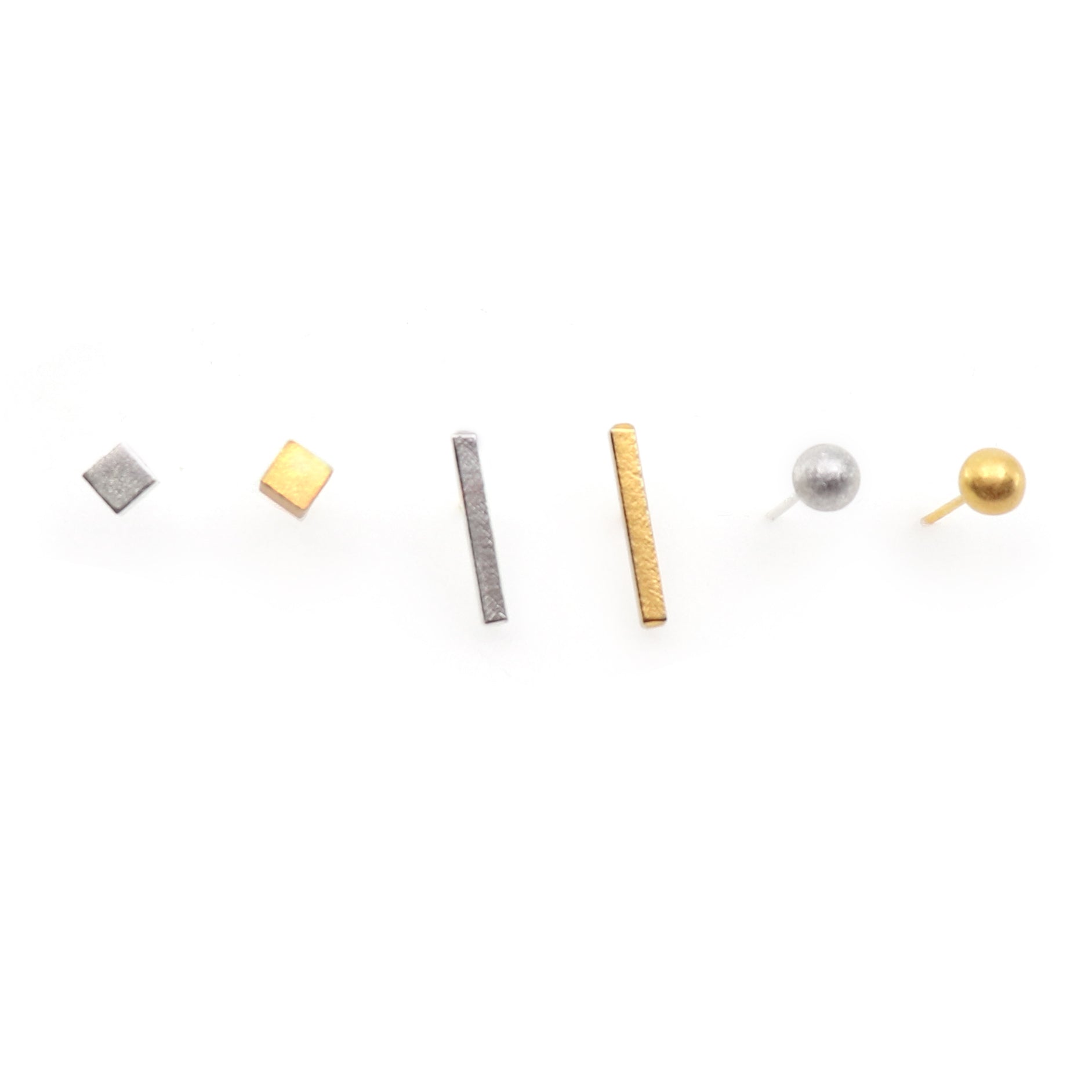 Set of small geometric earrings on a white background