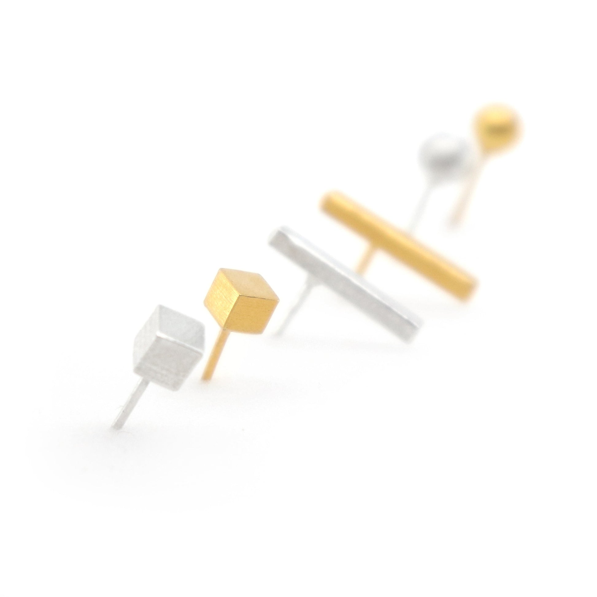 set of geometric stud earrings in gold and white on a white background