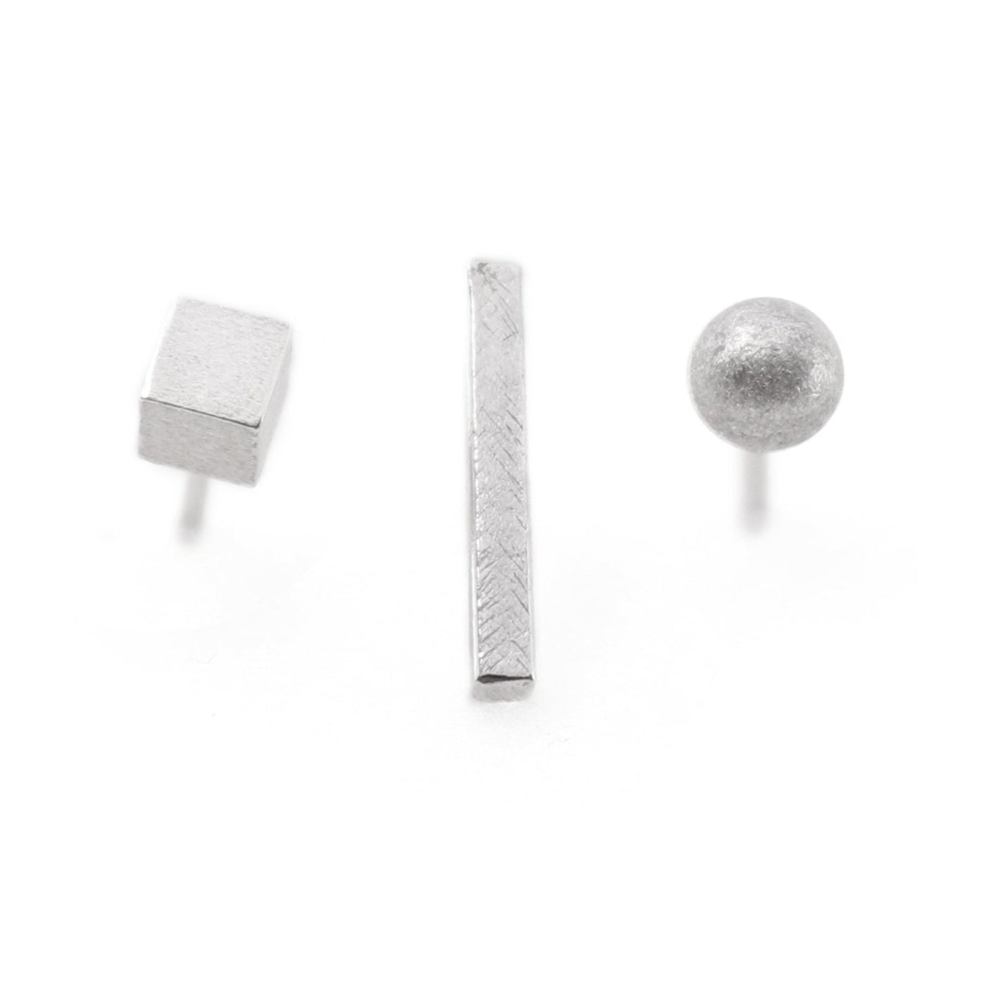 Set of three silver earrings on a white background