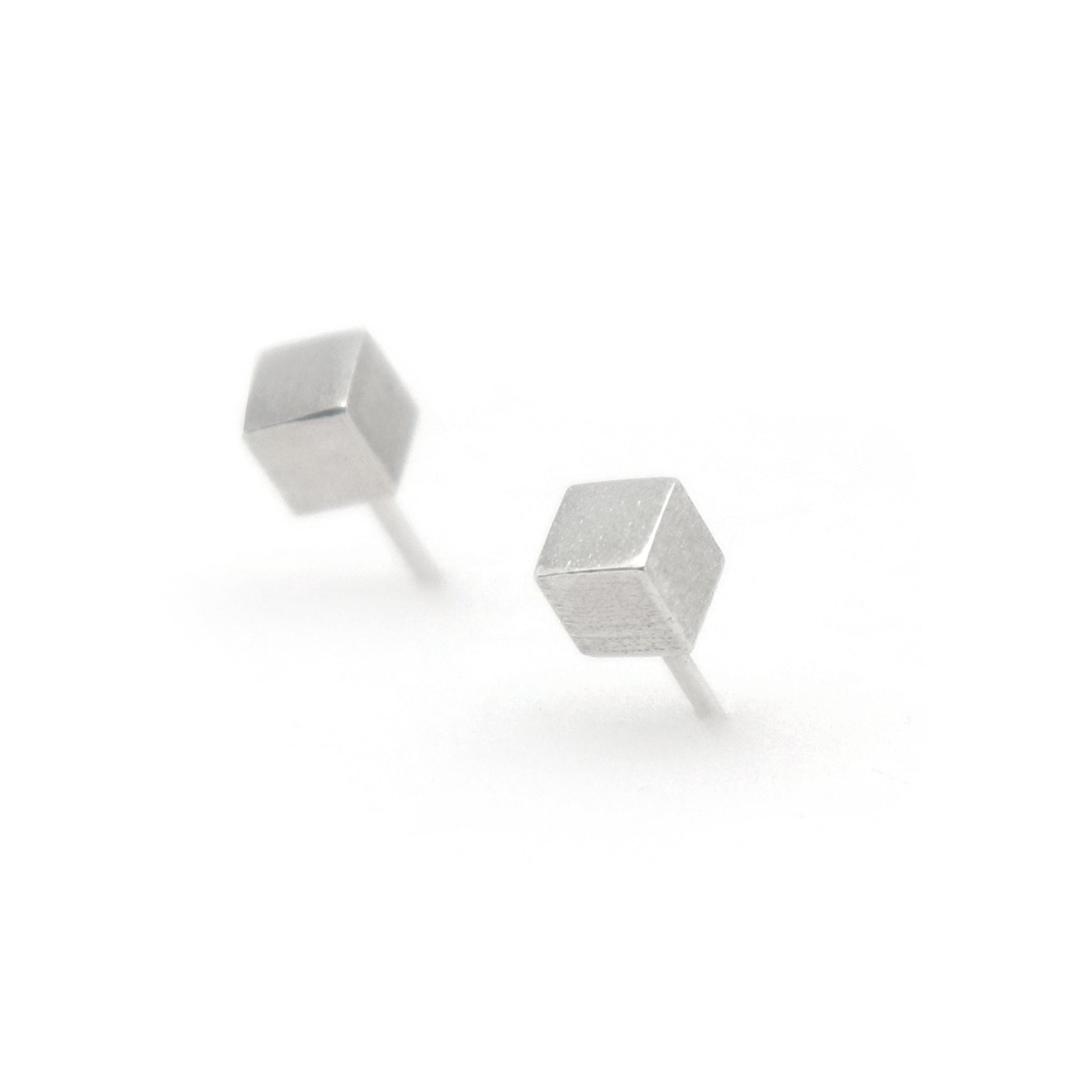 Pair of silver geometric cube stud earrings on a white background