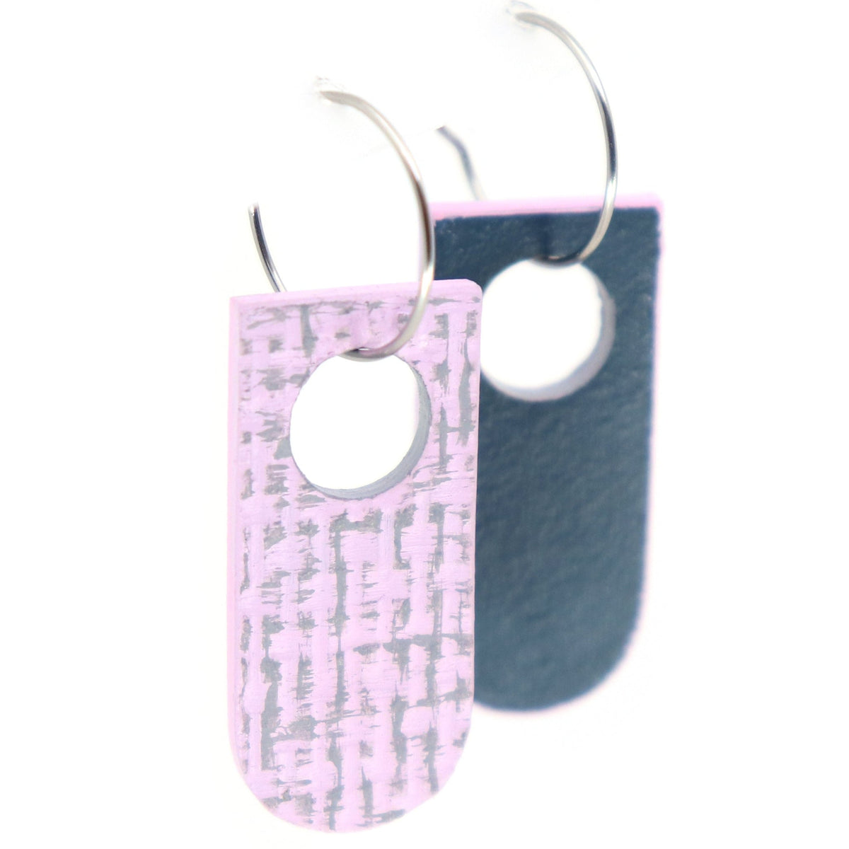 Pair of reversible earrings with one side in pink and grey, the other in navy blue  on a white background