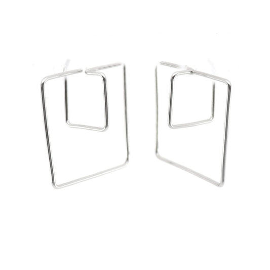 A pair of stainless steel double hoop geometric earrings with a 3d cube design, displayed against a plain white background.