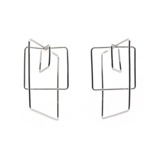 A pair of geometric steel wire hoop earrings with triple square forms creatign a 3d cube, shown on a plain white background.