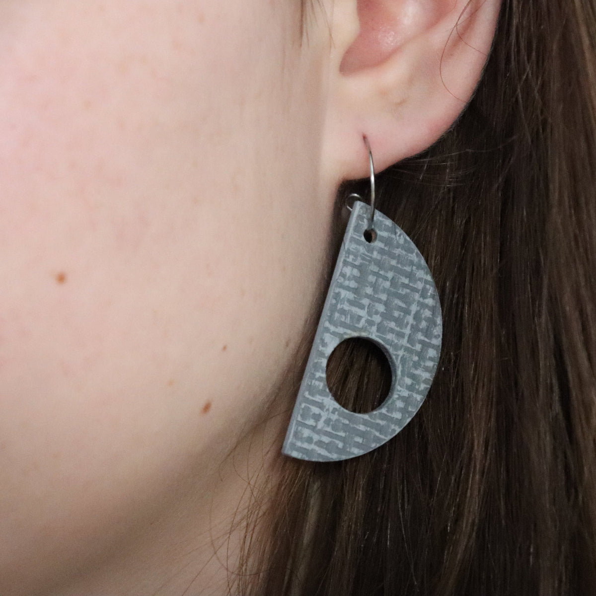 Earring with geometric pattern worn by a person