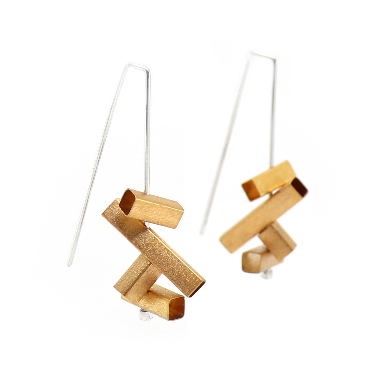 Gold and silver geometric earrings on a white background