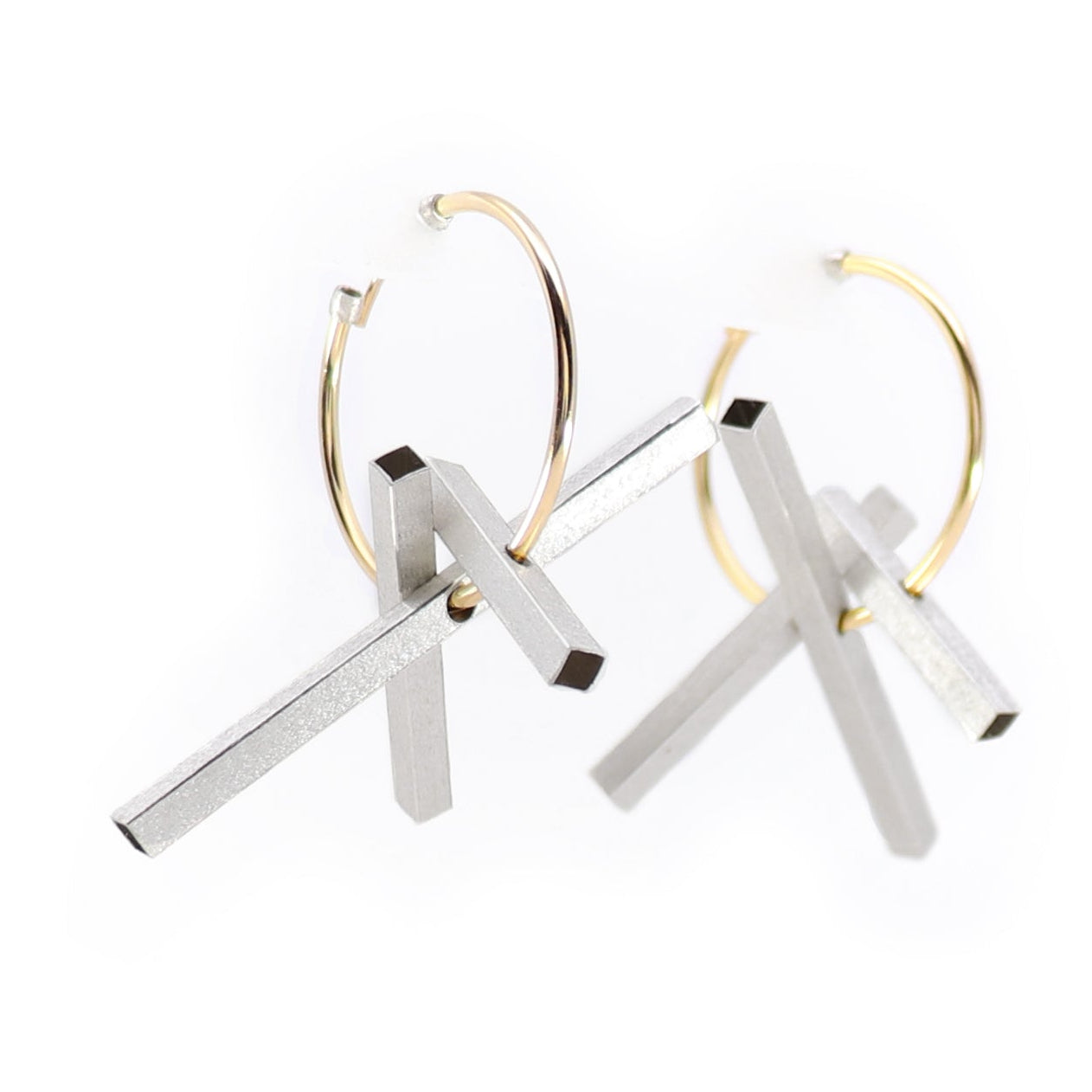 Pair of gold hoop earrings with silver bars on a white background