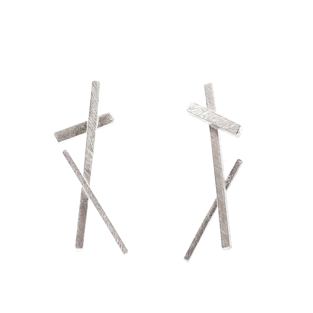 Pair of silver cross-shaped earrings on a white background