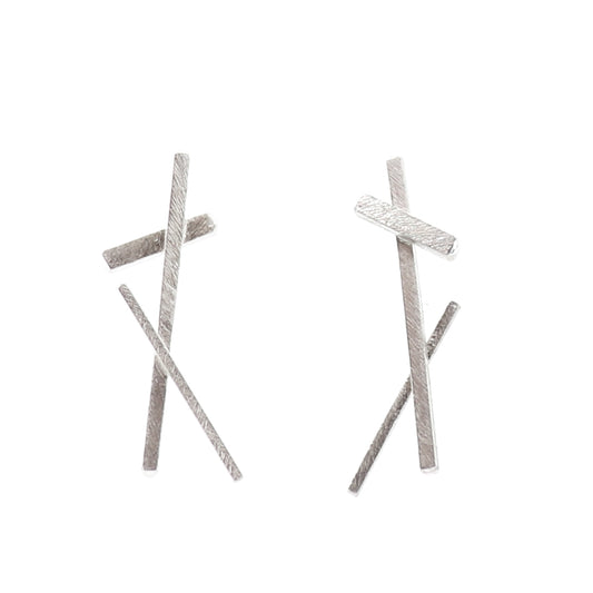 Pair of silver cross-shaped earrings on a white background