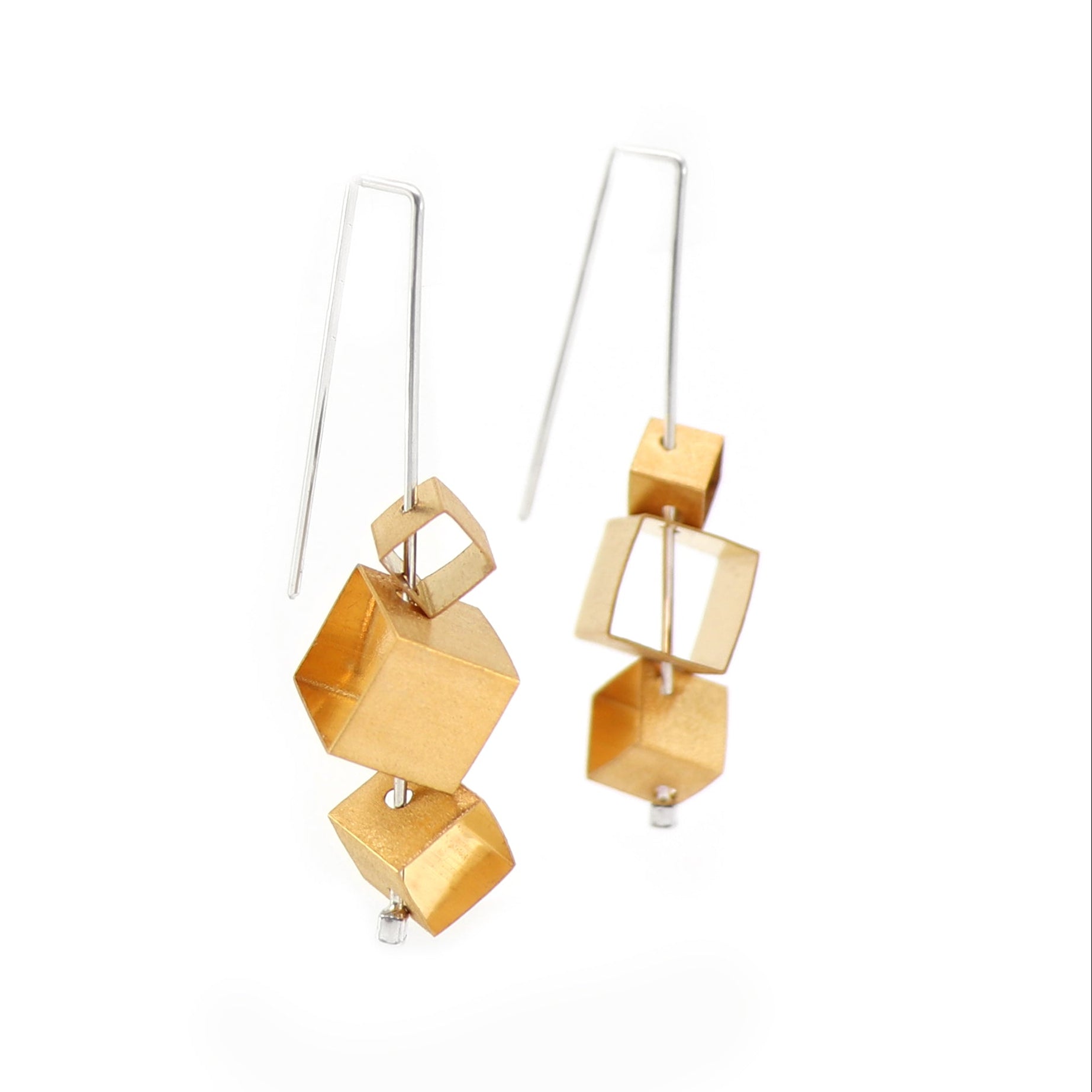 Gold geometric cubes on silver wire earrings on a white background