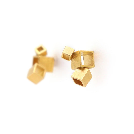 Gold geometric earrings on a white background