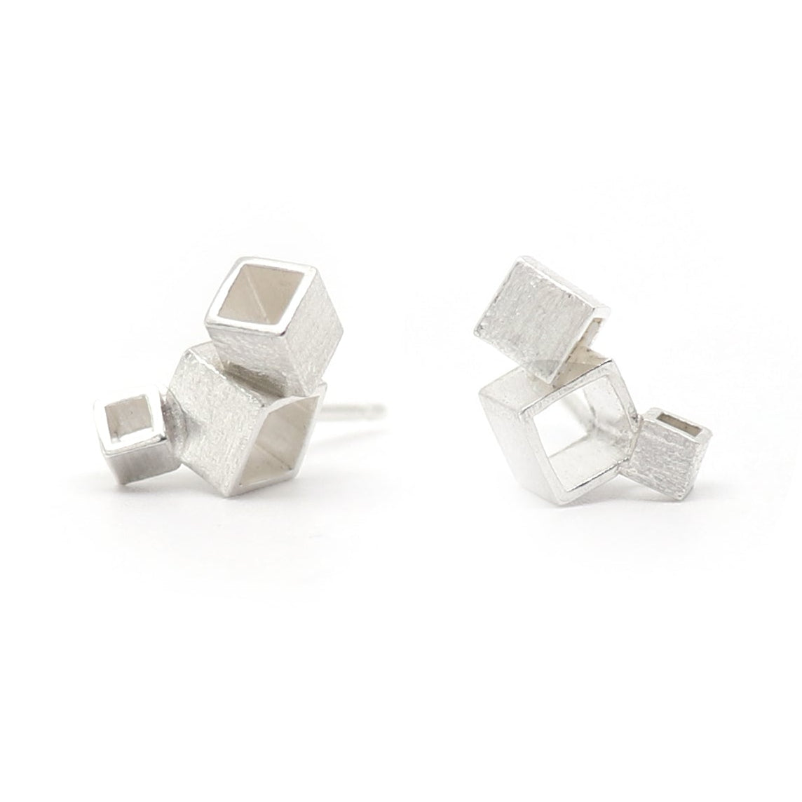 Silver triple cube geometric studs earrings with white background