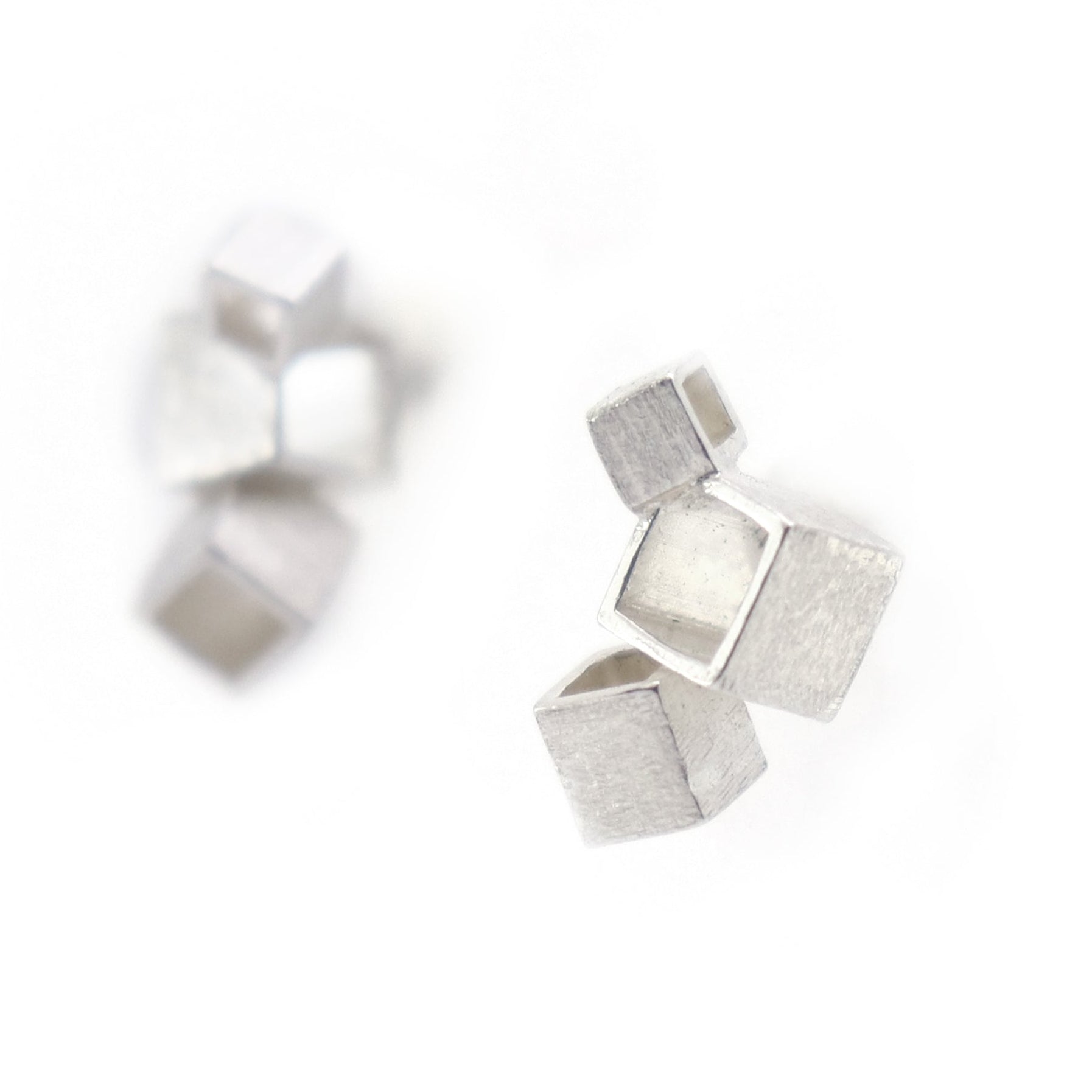 Silver geometric earrings on a white background