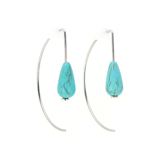 Turquoise teardrop earrings on curved wire against a white background