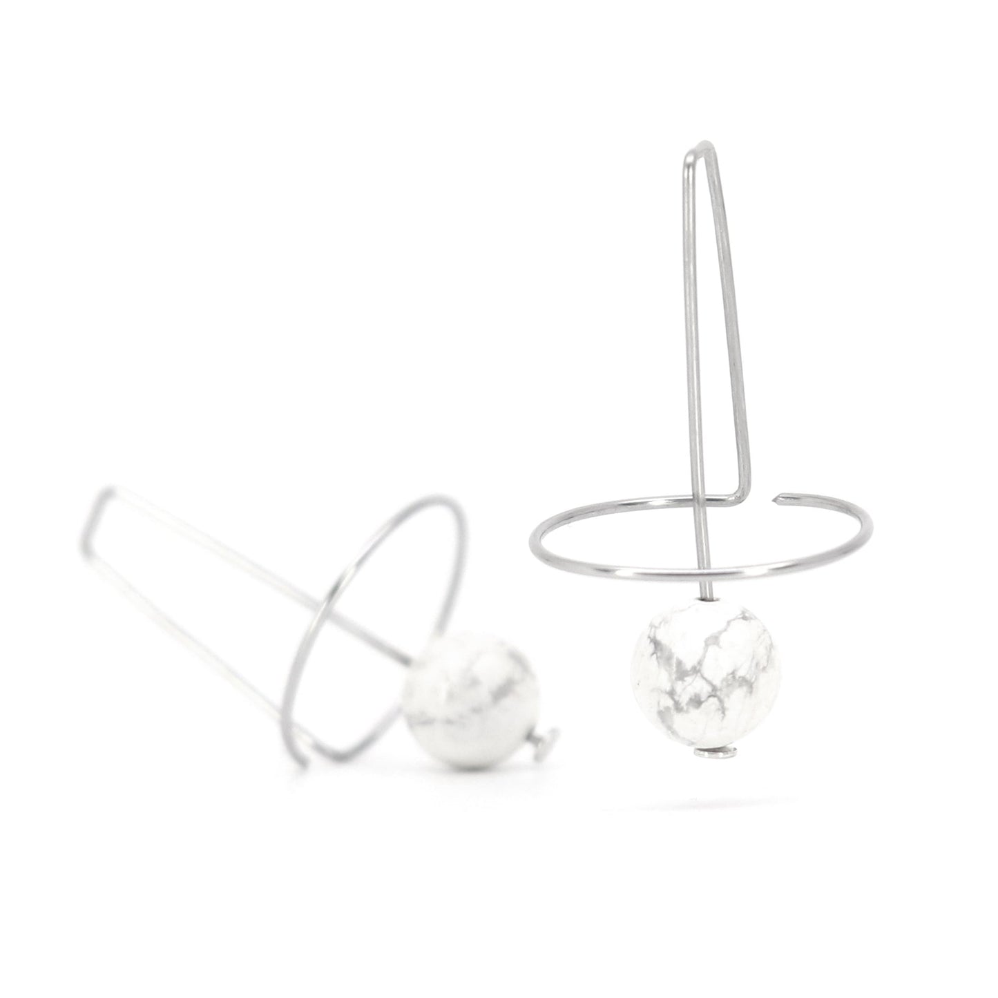 sculptural artistic wire earrings with howlite beads on white background