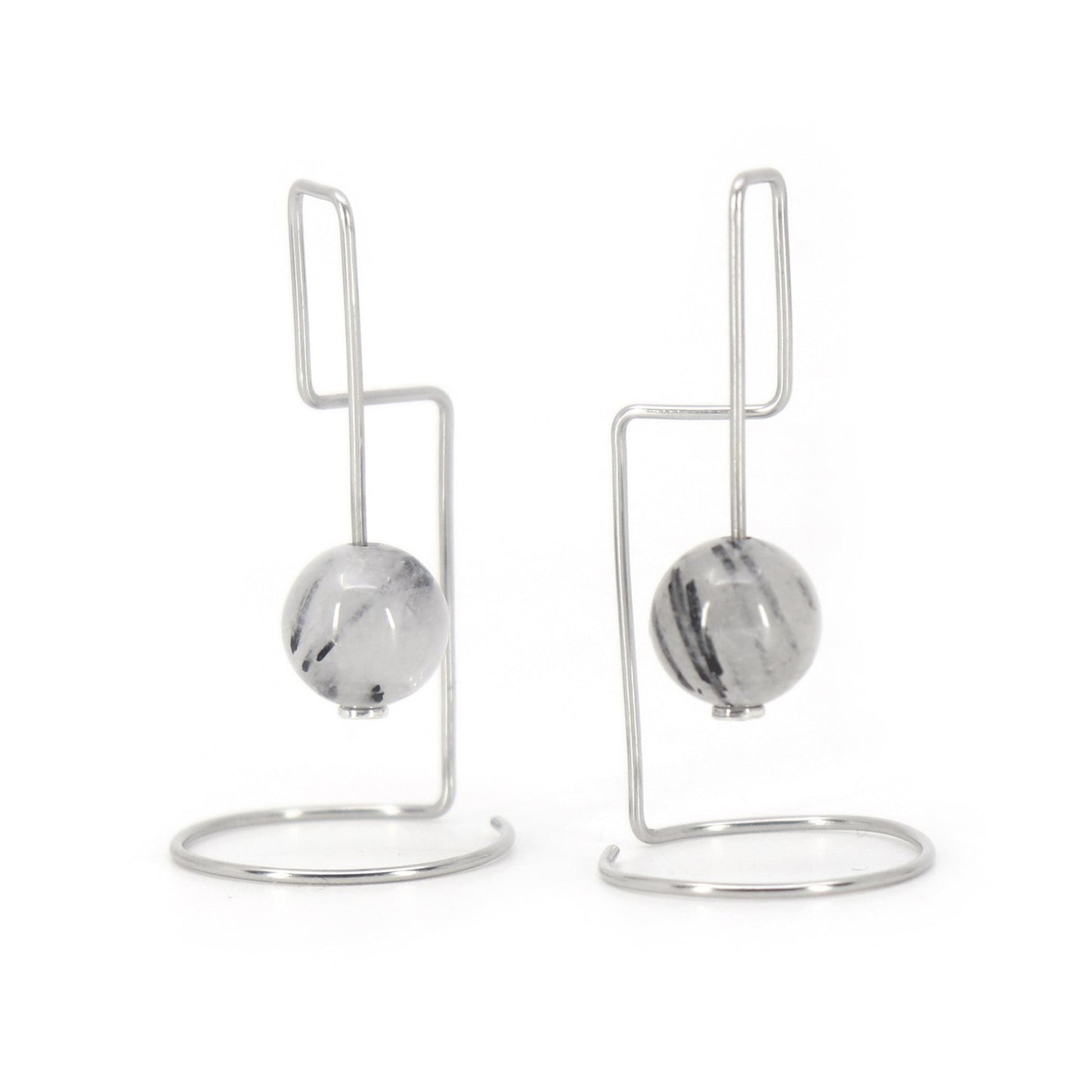 Pair of architectural earrings with rutilated agate beads on a white background