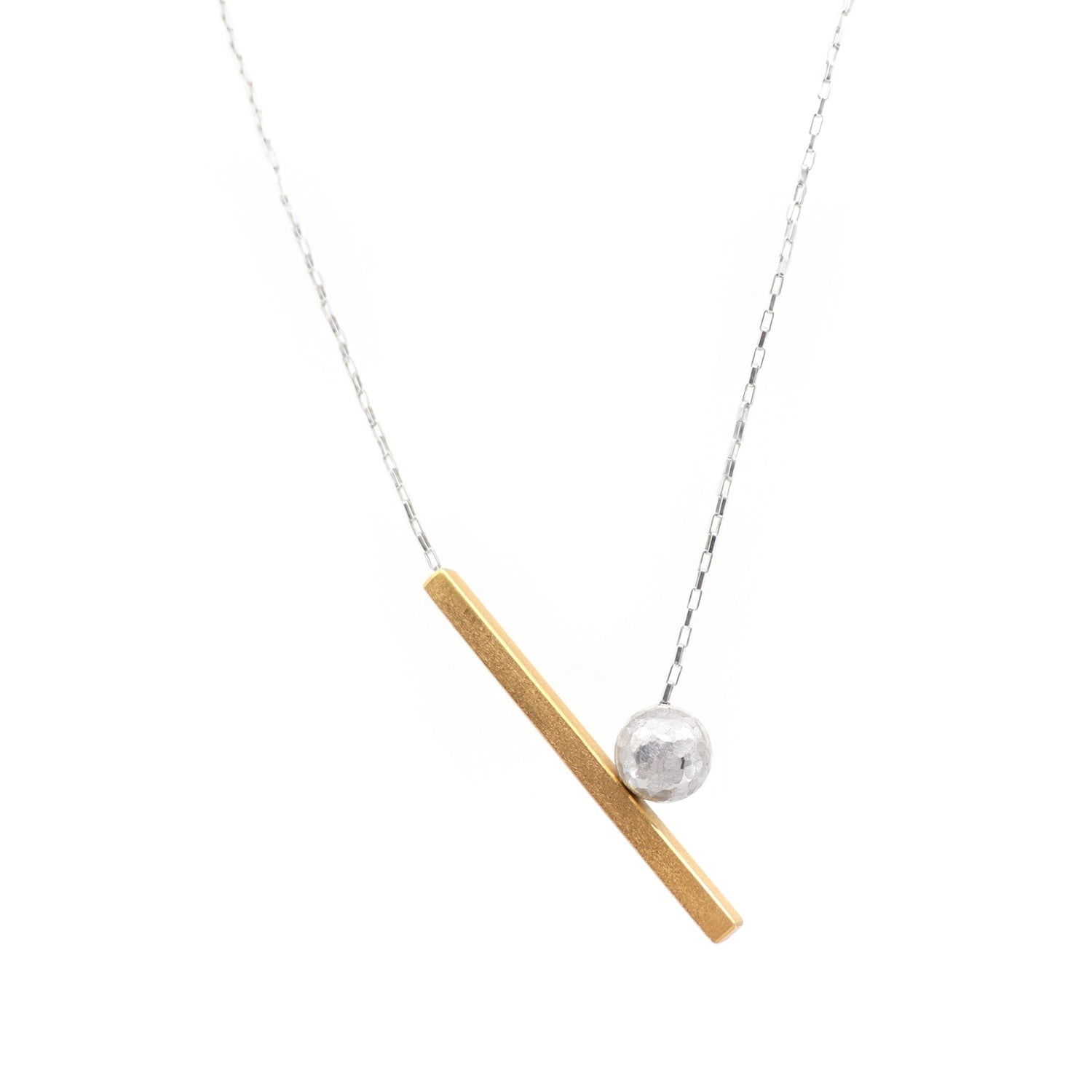 Necklace with a gold bar and silver sphere pendant on a white background