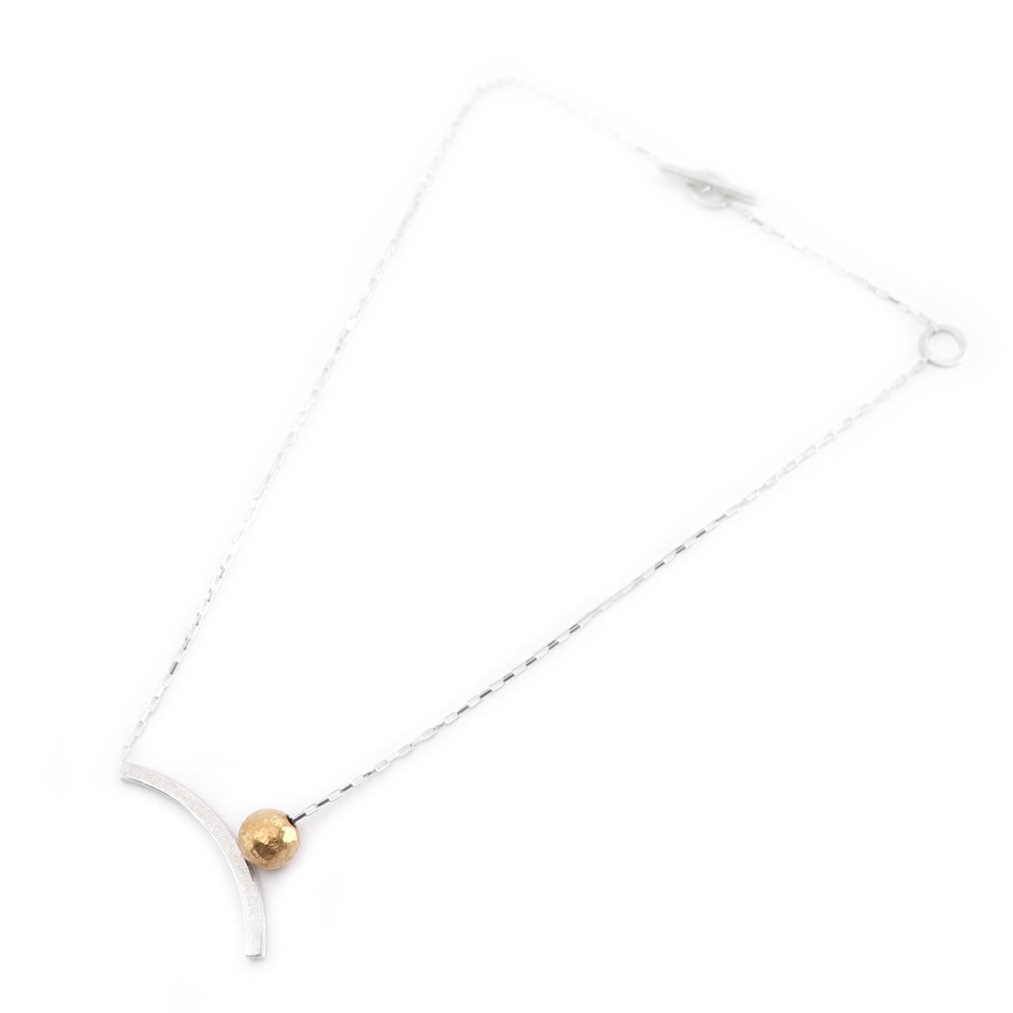 Necklace with a gold bead and curved silver on a white background