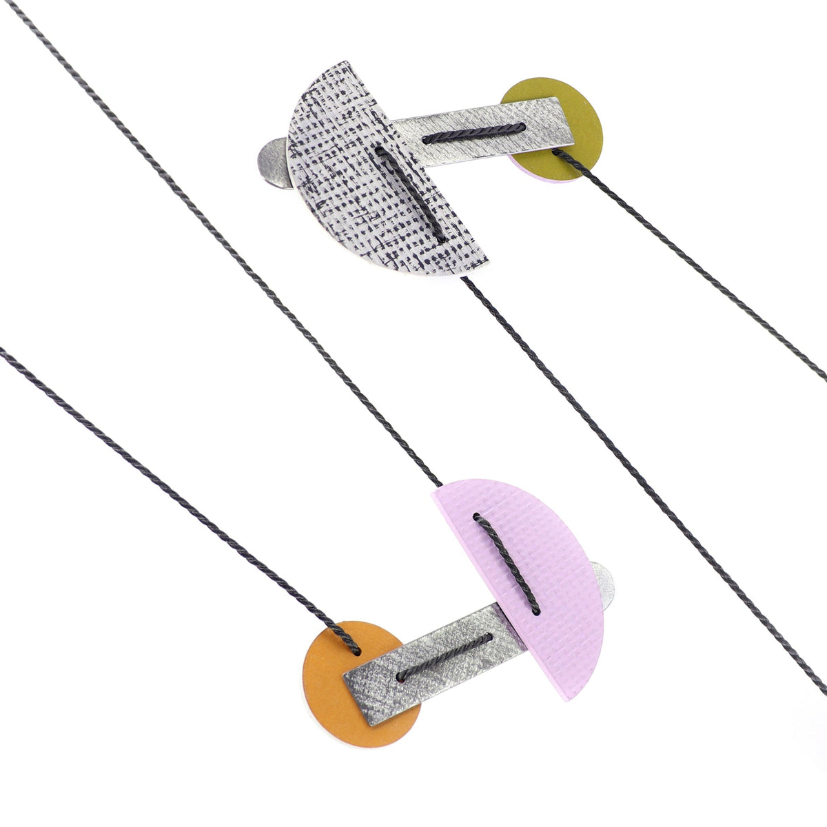 2 modernist necklaces laying side by side