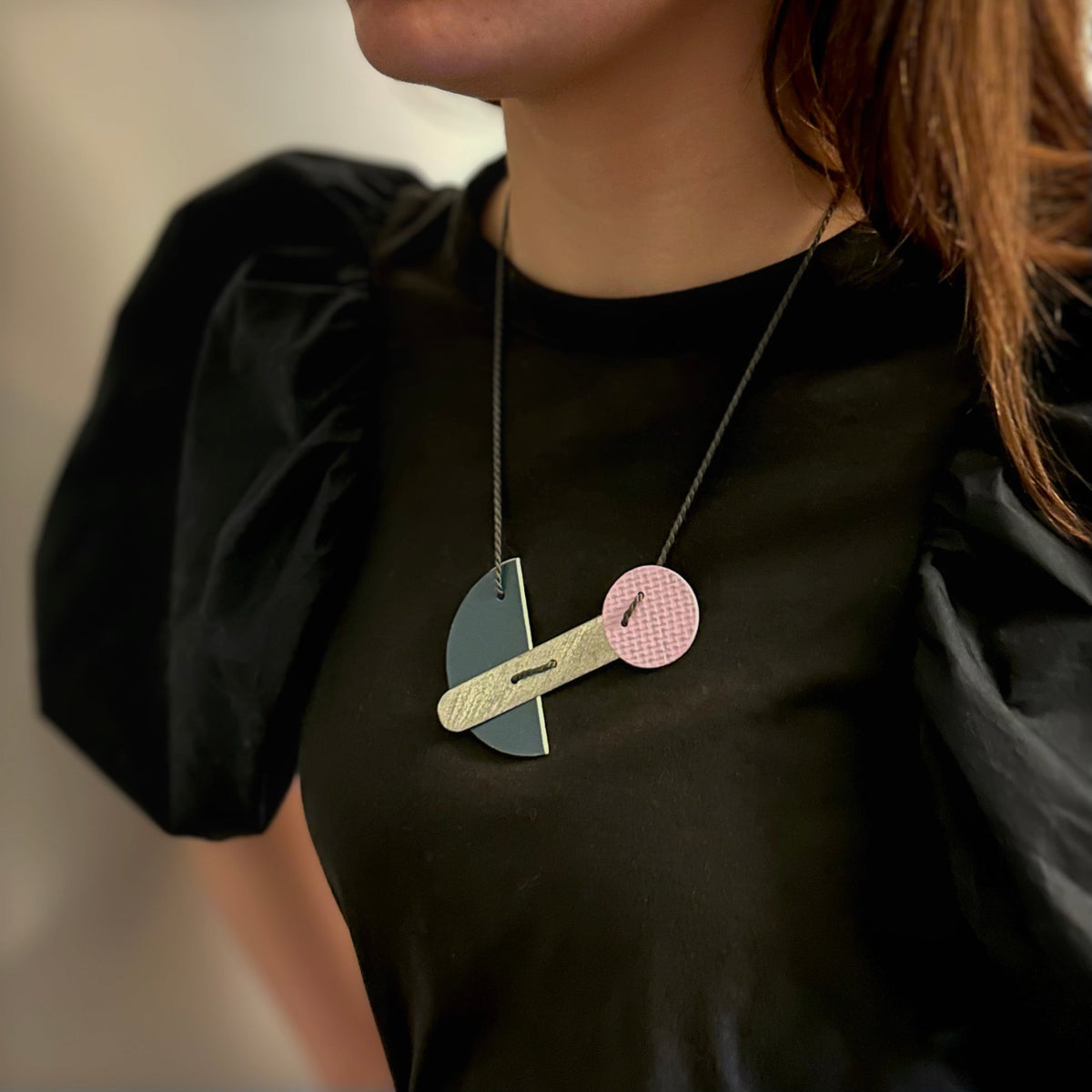 Linoleum necklace in  lilac and navy blue worn by model