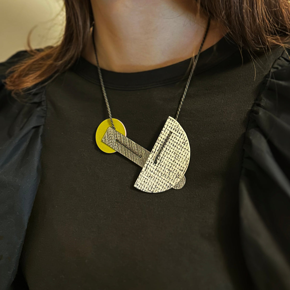 linoleum statement necklace in white and moss green with slack topteel, modelled with b
