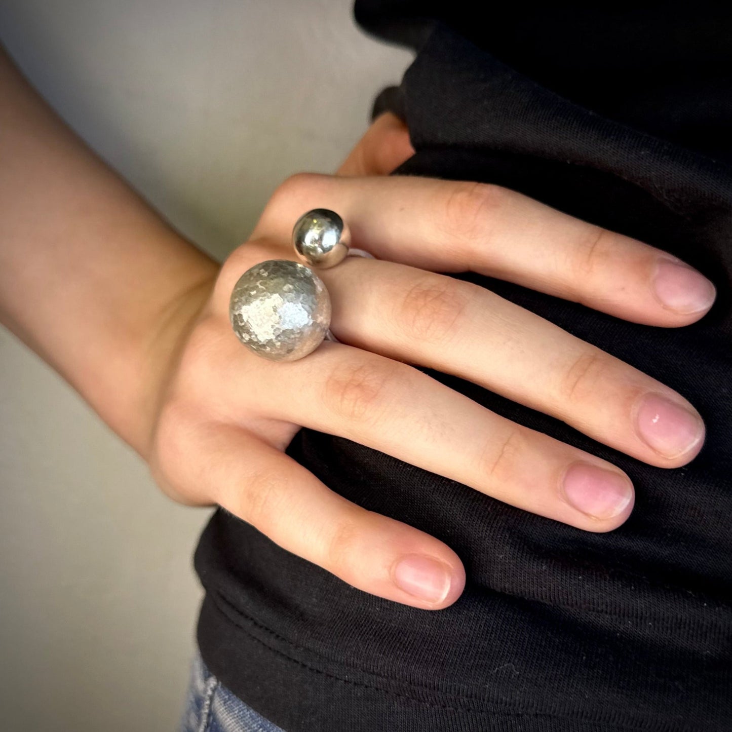Hand wearing statement ring with 2 orbs 