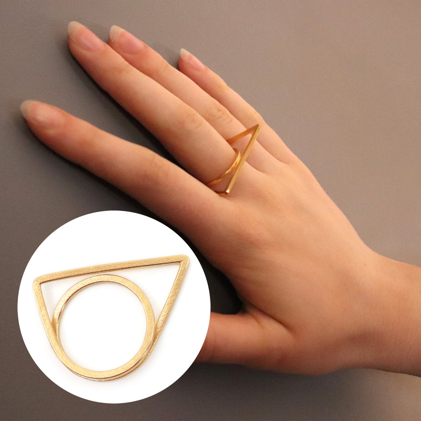 Gold geometric ring on a hand with a close-up inset on a neutral background