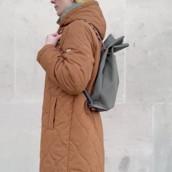 Olive-grey faux pleather convertible bag going from back to shoulder