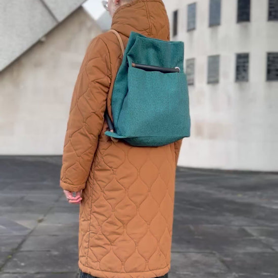 teal textile convertible bag going from back to shoulder