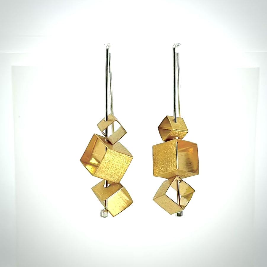 rotating cubist drop earrings in gold and silver