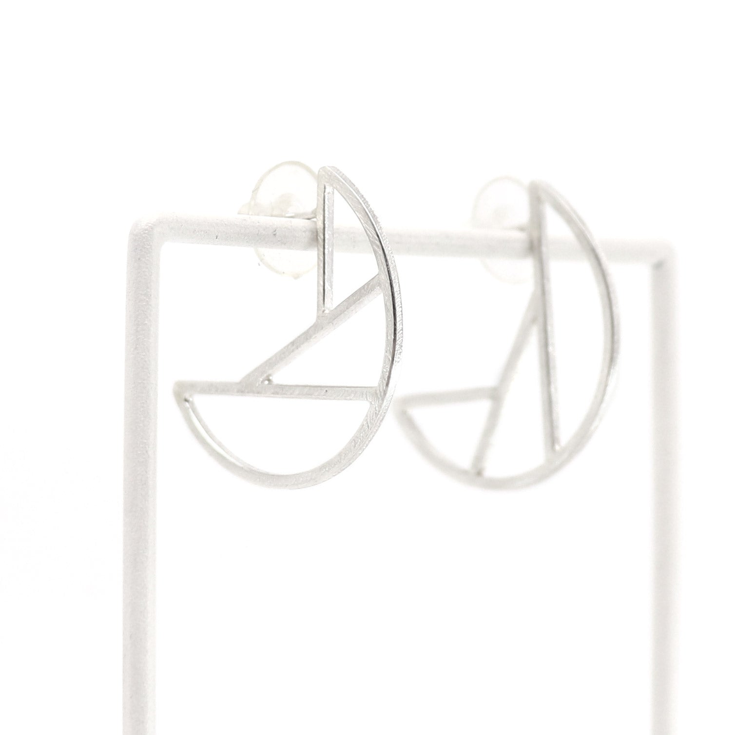 Silver geometric hoop earrings on a white background